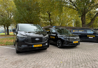 Three black vans with yellow Intertek branding. 