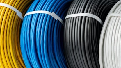 A Close-Up Photo of Four Spools of Electrical Wire, Each Wound in a Different Color.