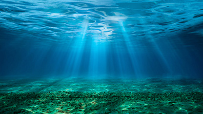 Undersea image showing rays of light from above through blue spectrum