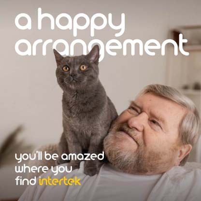 A man smiling at a cat shitting on his shoulder